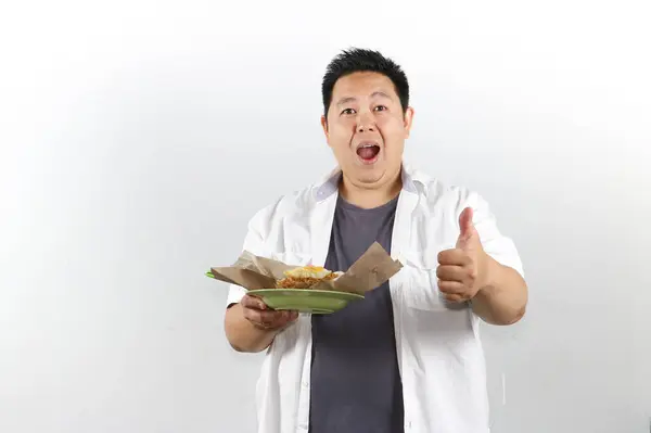 Elinde Endonezya usulü kızarmış pilav tutan mutlu bir adam.