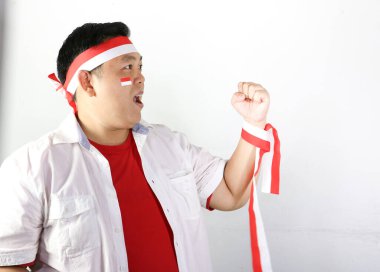 Endonezya bayrağı taşıyan kırmızı tişörtlü genç Endonezyalı adam.