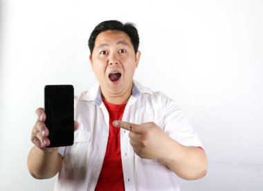 Beyaz arka planda cep telefonu tutan Asyalı adamın stüdyo fotoğrafı.