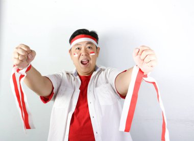 Asyalı doktor beyaz tişört ve kırmızı sargı bezi giyiyor. Kırmızı kurdele tutuyor. Başarıyı kutluyor.