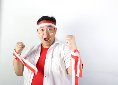 Kırmızı tişörtlü, futbol toplu Asyalı adam.