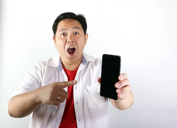 Asyalı genç adam boş bir akıllı telefon ekranı gösteriyor.