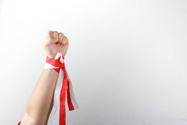 Beyaz arka planda kırmızı kurdele tutan bir adam..