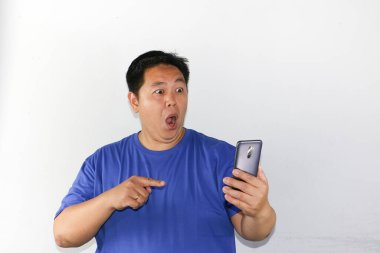 Adamın elinde şok olmuş bir yüz ifadesi olan akıllı bir telefon vardı.