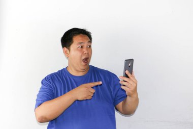 Akıllı telefonlu Asyalı adam şaşırdı ve şok oldu. beyaz arkaplanda izole.