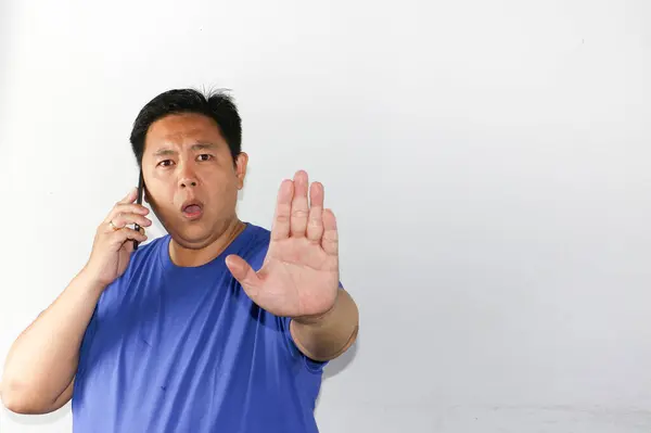 Reddetme jesti, akıllı, sıradan gömlekli, beyaz arka planı olan, cep telefonu tutan Asyalı bir adam.