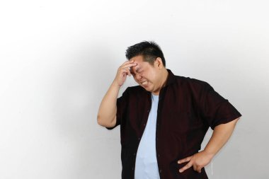 Başı ağrıyan bir adam, başını tutuyor, kötü hissediyor, acı çekiyor.