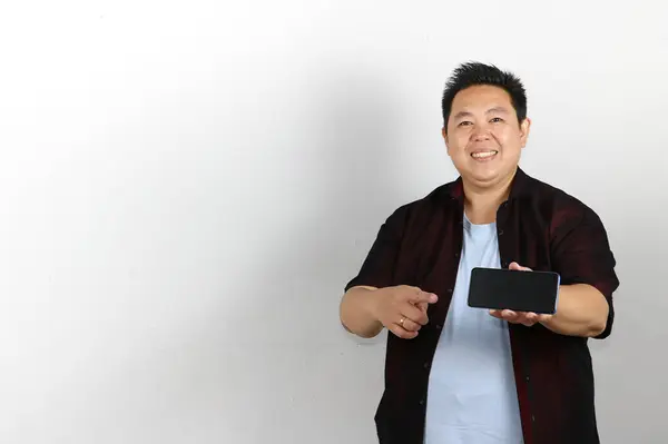 Gülümseyen genç adam cep telefonu tutarak