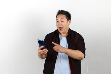 Vay be, Asyalı adam akıllı telefonuna bakıyor ve sürpriz yapıyor.