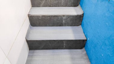 Temiz, soyut desenli, plastik gri halı merdivenlerde yüzme havuzuna gidiyor..