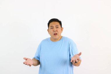Kafası karışmış Asyalı adam, elleri beyazın üzerinde izole bir şekilde el kol hareketi yapıyor.