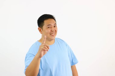 Gülümseyen Asyalı adam parmak ile yukarı doğru işaret ediyor bir fikir jesti var