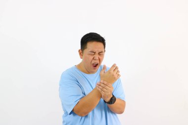 Beyaz arka planda bileğini tutarak acı çeken bir adam.