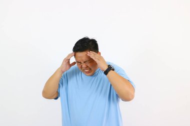 Genç Asyalı adam çok kötü baş ağrısı çekiyor.