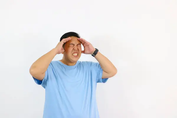 Başı ağrıyan ve acı çeken bir adam beyazlar içinde izole edilmiş.