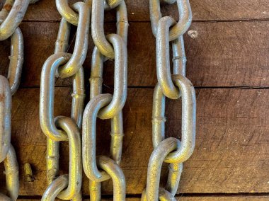 Kırsal ahşap yüzeyde doğal dokusu olan güçlü metal bir zincir. 