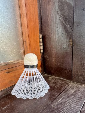 Badminton mekik horozu, tahta pencere eşiğinde doğal ışıkla dinleniyor. 