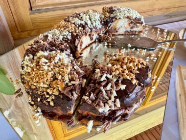 Tahtada sunulan fındıklı ve dilimli çikolatalı pasta.