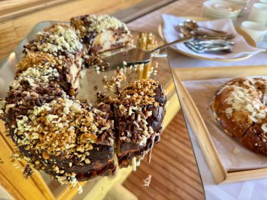 Tahtada sunulan fındıklı ve dilimli çikolatalı pasta.