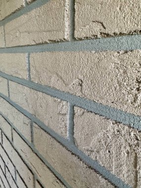 Kabataslak desenli ve görünen havan hatları arka planlı bej tuğla duvara yakın plan