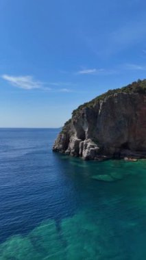 Adriyatik Denizi 'nin kayalık orman kıyılarının güneşli bir günde havadan görünüşü. Budva Karadağ' ın manzarası. Dikey video. 