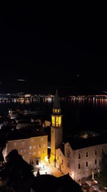 Budva üzerinde uçan videoda St. Johns Kilisesi, sembolik çan kulesi ve çarpıcı deniz manzaralı tarihi kasaba vurgulanıyor.