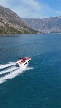 Montenegro 'daki Kotor Körfezi' nde uçan teknelerin büyüleyici insansız hava aracı görüntüleri. Dikey video.