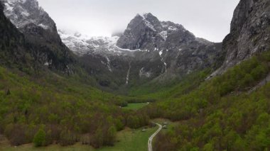 Prokletije Montenegro Drone 'daki Karlı Dağlar ve Yeşil Yol. Yüksek kalite 4K görüntü. Prokletije Milli Parkı