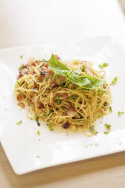 Spagetti pastırmalı sarımsak ve üstünde tatlı fesleğen. .