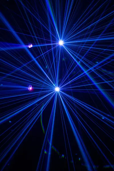 Karanlık bir atmosferde, genellikle konserlerde, kulüplerde ya da aydınlatıcı ışık gösterilerinde görülen dramatik bir lazer ya da sahne aydınlatma gösterisi. Koyu arkaplanda mavi ve mor ışıklar.