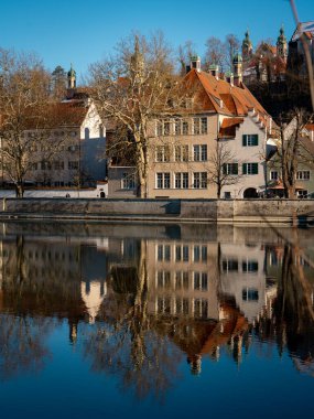 Bavyera 'daki Landsberg Am Lech' in tarihi kasabası: Donmuş bir nehri ve açık mavi gökyüzü altındaki renkli evleri olan kış cazibesi. Yüksek kalite fotoğraf