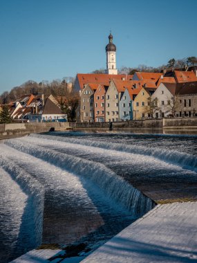 Bavyera 'daki Landsberg Am Lech' in tarihi kasabası: Donmuş bir nehri ve açık mavi gökyüzü altındaki renkli evleri olan kış cazibesi. Yüksek kalite fotoğraf