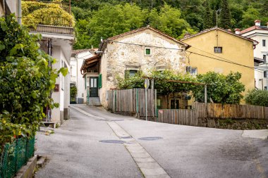 Kale Harabelerinden Vipava 'nın Resimli Manzarası: Kırmızılı Çatı ve Kilise Kulesi Önplanda Çiçek Açan Çiçekler ve Arka planda Yuvarlanan Tarlalar, Slovenya. 