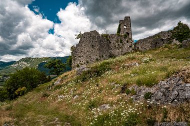 Slovenya 'daki Vipava Harabeleri: Manzaralı Vipava Vadisi' ndeki dramatik bulutlarla dolu bir gökyüzünün altında sarmaşık duvarlarıyla kaplı antik taş duvarlar. Yüksek kalite fotoğraf