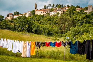 Slovenya 'nın Manzaralı Tepe Kenti Stanjel: Karst Bölgesi' nde Geleneksel Taş Evler ve Çiçek Yeşiller Altında Yükselen Tarihi Kilise Kulesi. Yüksek kalite fotoğraf