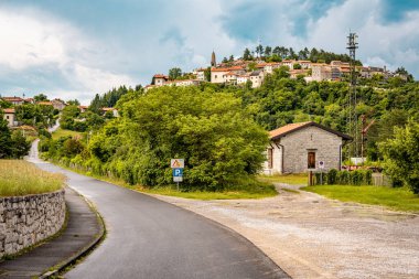 Slovenya 'nın Manzaralı Tepe Kenti Stanjel: Karst Bölgesi' nde Geleneksel Taş Evler ve Çiçek Yeşiller Altında Yükselen Tarihi Kilise Kulesi. Yüksek kalite fotoğraf