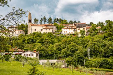 Kale Harabelerinden Vipava 'nın Resimli Manzarası: Kırmızılı Çatı ve Kilise Kulesi Önplanda Çiçek Açan Çiçekler ve Arka planda Yuvarlanan Tarlalar, Slovenya. 