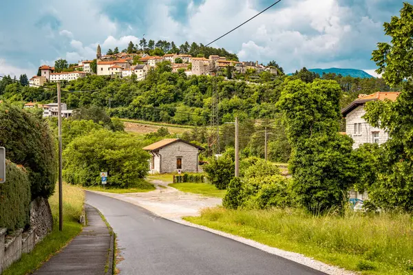 Slovenya 'nın Manzaralı Tepe Kenti Stanjel: Karst Bölgesi' nde Geleneksel Taş Evler ve Çiçek Yeşiller Altında Yükselen Tarihi Kilise Kulesi. Yüksek kalite fotoğraf
