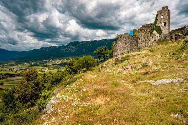 Slovenya 'daki Vipava Harabeleri: Manzaralı Vipava Vadisi' ndeki dramatik bulutlarla dolu bir gökyüzünün altında sarmaşık duvarlarıyla kaplı antik taş duvarlar. Yüksek kalite fotoğraf