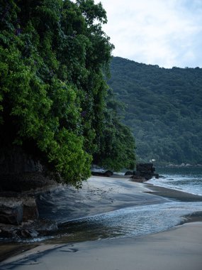 Rio De Janeiro yakınlarındaki Ilha Grande 'de Huzurlu Plaj: Kibar Dalgalar Rocky Outcrops ile Sandy Shore' a vuruyor ve Tropikal Brezilya Cennetindeki yemyeşil tepeler. Yüksek kalite fotoğraf