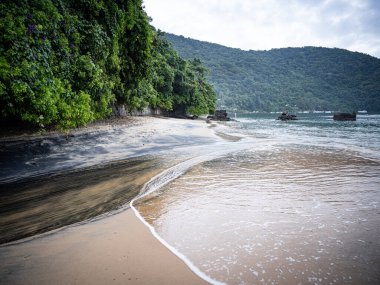 Rio De Janeiro yakınlarındaki Ilha Grande 'de Huzurlu Plaj: Kibar Dalgalar Rocky Outcrops ile Sandy Shore' a vuruyor ve Tropikal Brezilya Cennetindeki yemyeşil tepeler. Yüksek kalite fotoğraf