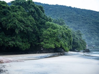 Rio De Janeiro yakınlarındaki Ilha Grande 'de Huzurlu Plaj: Kibar Dalgalar Rocky Outcrops ile Sandy Shore' a vuruyor ve Tropikal Brezilya Cennetindeki yemyeşil tepeler. Yüksek kalite fotoğraf