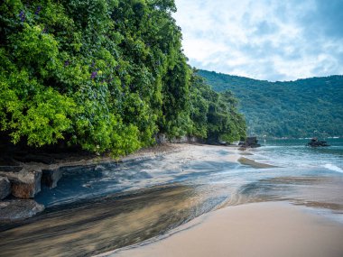 Rio De Janeiro yakınlarındaki Ilha Grande 'de Huzurlu Plaj: Kibar Dalgalar Rocky Outcrops ile Sandy Shore' a vuruyor ve Tropikal Brezilya Cennetindeki yemyeşil tepeler. Yüksek kalite fotoğraf
