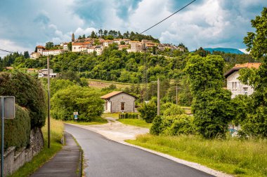 Slovenya 'nın Manzaralı Tepe Kenti Stanjel: Karst Bölgesi' nde Geleneksel Taş Evler ve Çiçek Yeşiller Altında Yükselen Tarihi Kilise Kulesi. Yüksek kalite fotoğraf