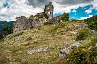 Slovenya 'daki Vipava Harabeleri: Manzaralı Vipava Vadisi' ndeki dramatik bulutlarla dolu bir gökyüzünün altında sarmaşık duvarlarıyla kaplı antik taş duvarlar. Yüksek kalite fotoğraf