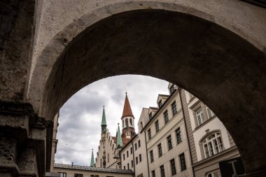 Marienplatz yakınlarında Münih 'teki Tarihi Oyuncak Müzesi: Kırmızı Çatılı ve Yeşil Spire çerçeveli Eski Kule dramatik Bulutlu Gökyüzüne Karşı Taş Kemer. Yüksek kalite fotoğraf