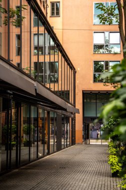 Modern Sokak Sahnesi Münih Merkezi: Sessiz bir şehir avlusunda cam cepheli ve yeşillikli çağdaş mimari. Yüksek kalite fotoğraf