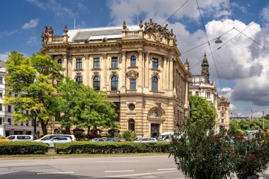 Münih 'teki Barok Mimari: Heykel Yüzlü Süslü Tarihi Bina, Kemerli Pencereler, Dekoratif Sütunlar ve Mavi Gökyüzü Altında Bulutlu Taş Detayları. Yüksek kalite fotoğraf