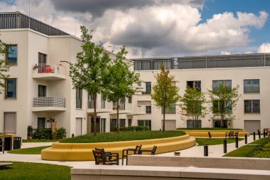 Freiham Münih Bavyera 'daki Modern Mimari: Geometrik cepheli Minimalist Bina, Büyük Pencereler ve Bulutlu Gök Altındaki Küçük Ağaç. Yüksek kalite fotoğraf