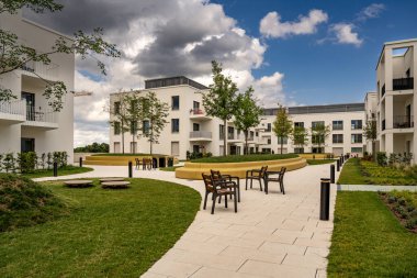 Freiham Münih Bavyera 'daki Modern Mimari: Geometrik cepheli Minimalist Bina, Büyük Pencereler ve Bulutlu Gök Altındaki Küçük Ağaç. Yüksek kalite fotoğraf